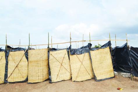 Bamboo mats lined with tarpaulin as toilet partitions.